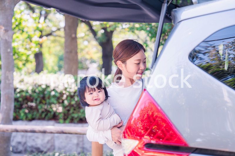 赤ちゃんと一緒に車に乗るお母さん