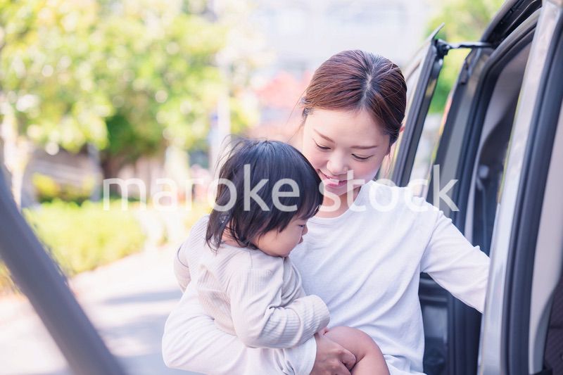 赤ちゃんと一緒に車に乗るお母さん