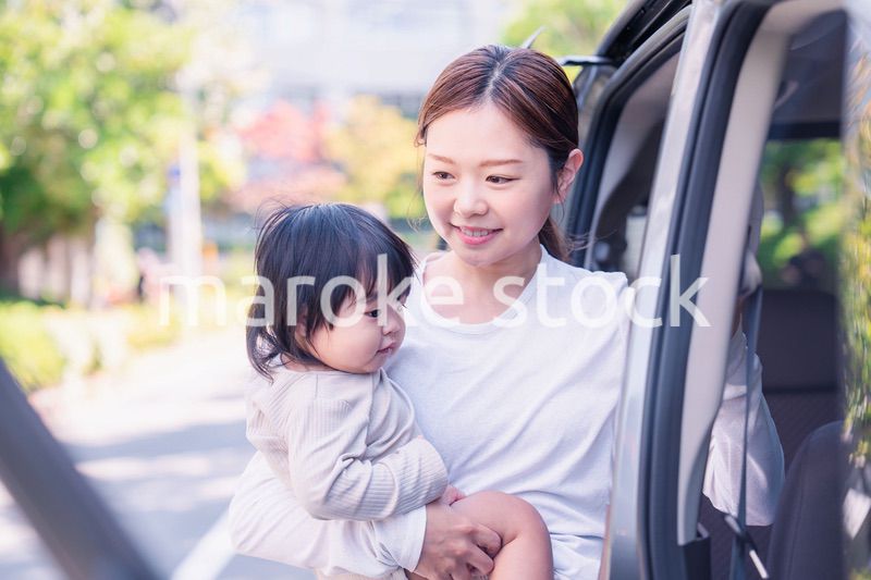 赤ちゃんと一緒に車に乗るお母さん