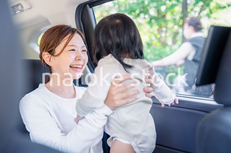 小さい子供と一緒にタクシーに乗るお母さん