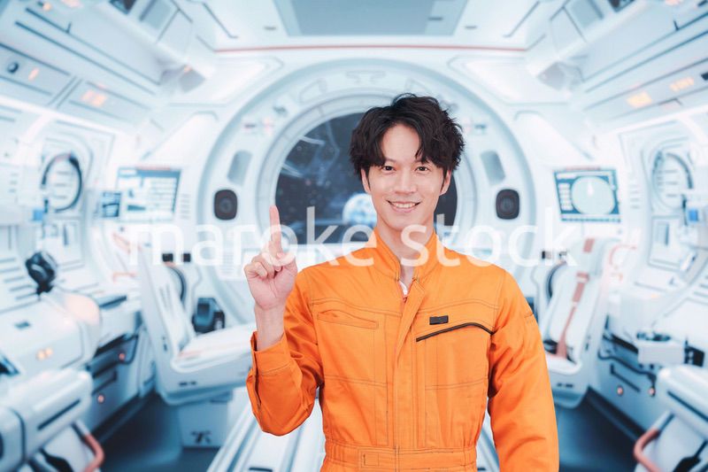 宇宙ステーションの中で働く若い男性の宇宙飛行士