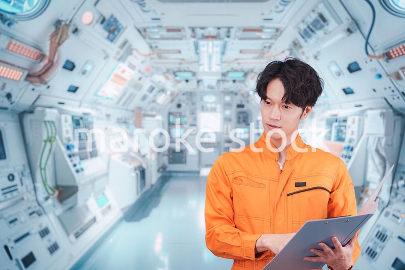 宇宙ステーションの中で働く若い男性の宇宙飛行士