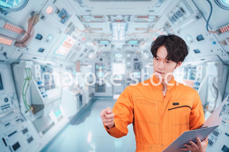 宇宙ステーションの中で働く若い男性の宇宙飛行士