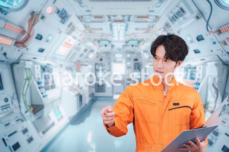 宇宙ステーションの中で働く若い男性の宇宙飛行士