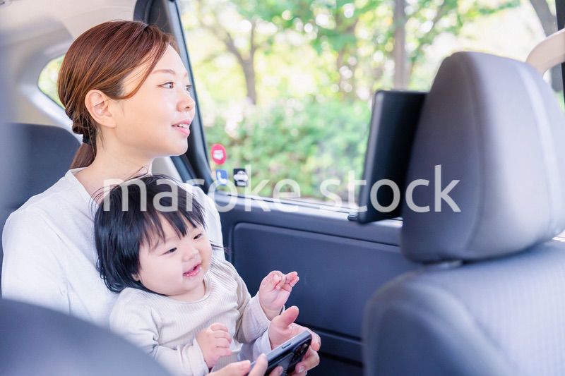 小さい子供と一緒にタクシーに乗るお母さん