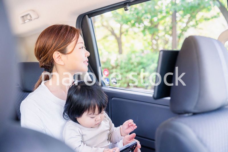 小さい子供と一緒にタクシーに乗るお母さん