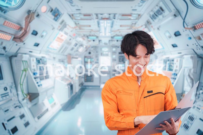宇宙ステーションの中で働く若い男性の宇宙飛行士