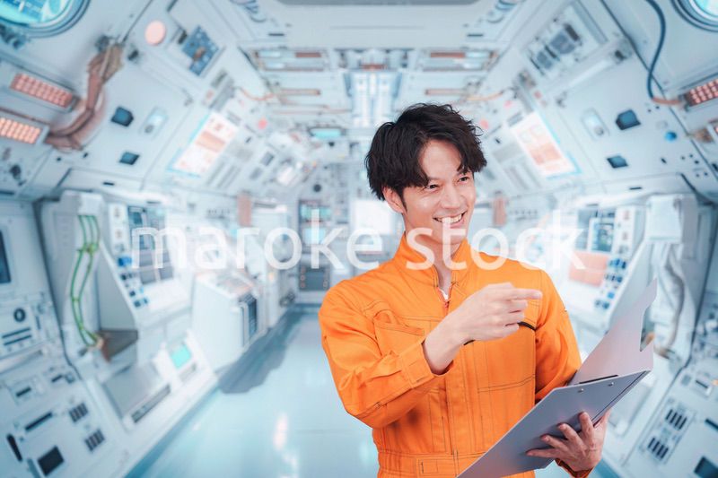 宇宙ステーションの中で働く若い男性の宇宙飛行士