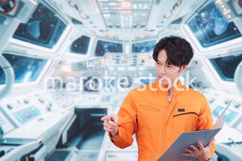 宇宙ステーションの中で働く若い男性の宇宙飛行士