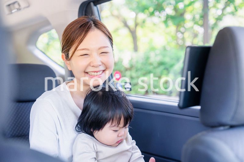 小さい子供と一緒にタクシーに乗るお母さん