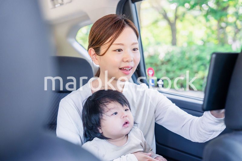 小さい子供と一緒にタクシーに乗るお母さん