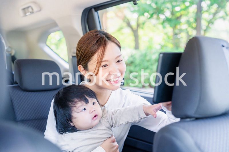 小さい子供と一緒にタクシーに乗るお母さん