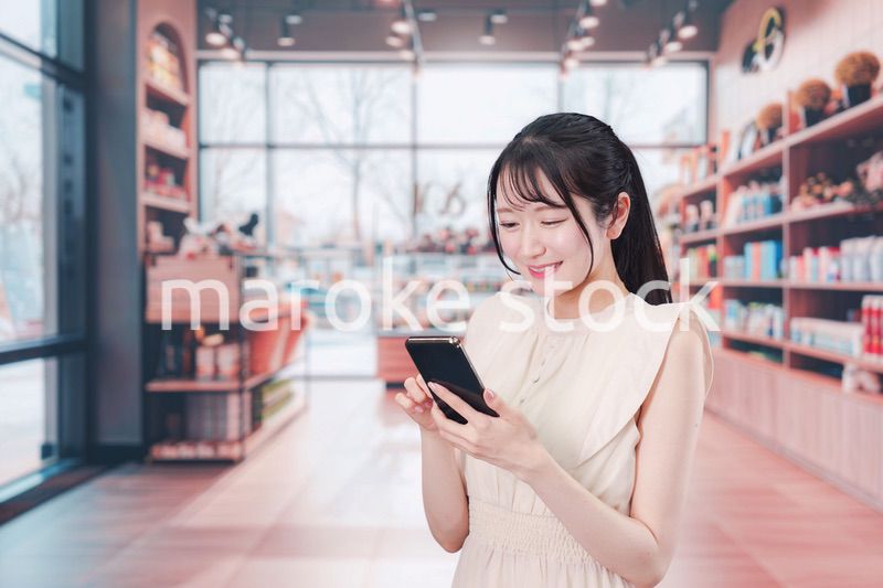 ショッピングをしながらスマホで検索をする若い女性