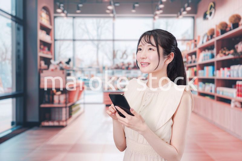 ショッピングをしながらスマホで検索をする若い女性