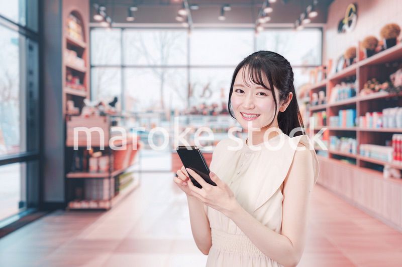 ショッピングをしながらスマホで検索をする若い女性