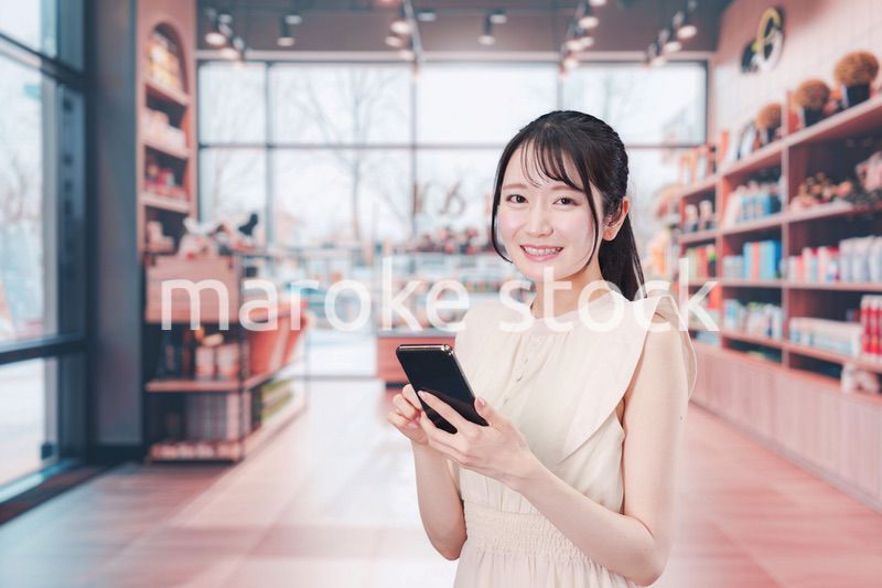 ショッピングをしながらスマホで検索をする若い女性