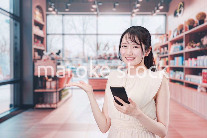 ショッピングをしながらスマホで検索をする若い女性