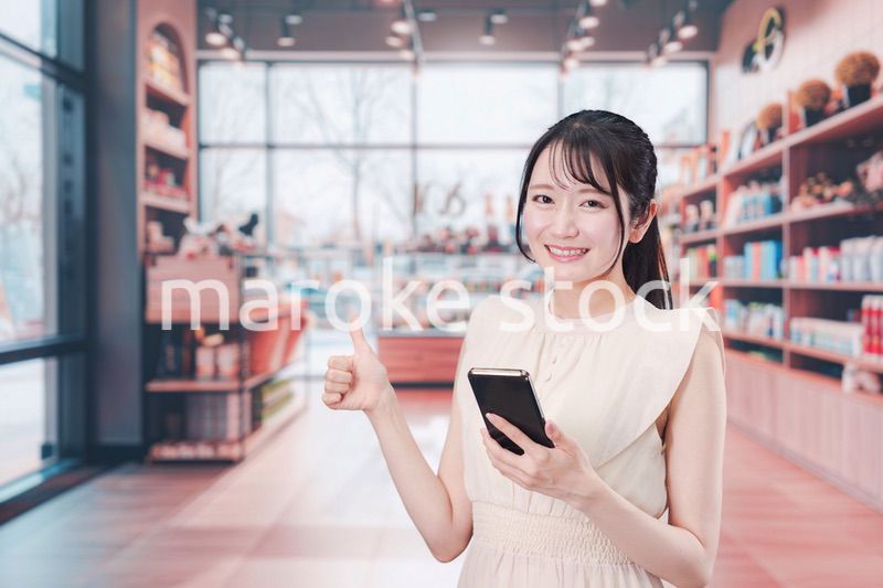 ショッピングをしながらスマホで検索をする若い女性