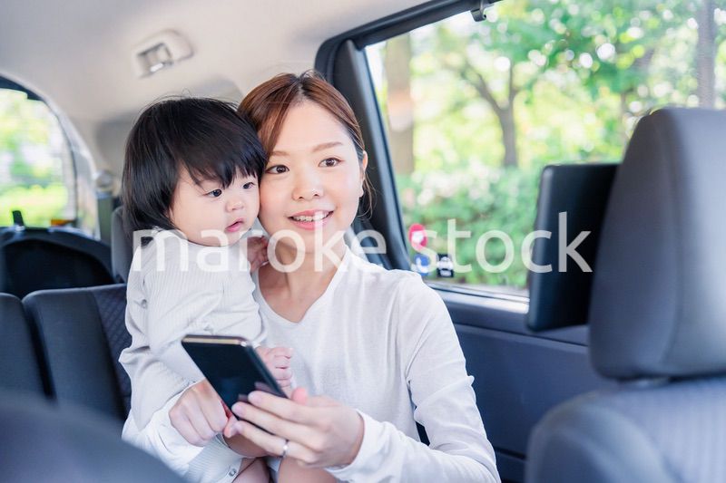 小さい子供と一緒にタクシーに乗るお母さん