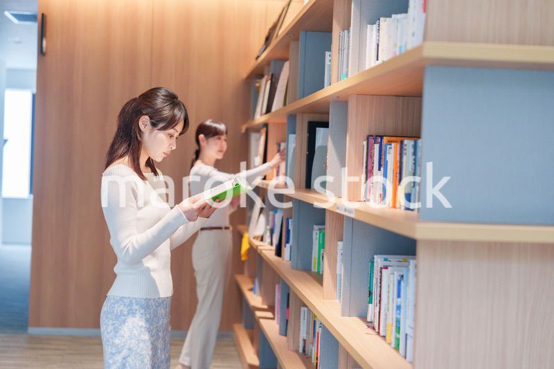 図書館で本を探す若い女性
