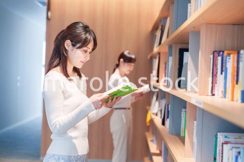 図書館で本を探す若い女性