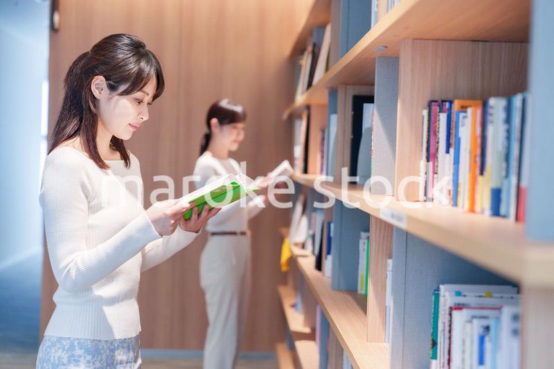 図書館で本を探す若い女性