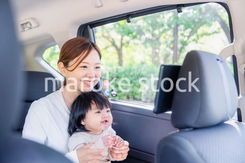 小さい子供と一緒にタクシーに乗るお母さん