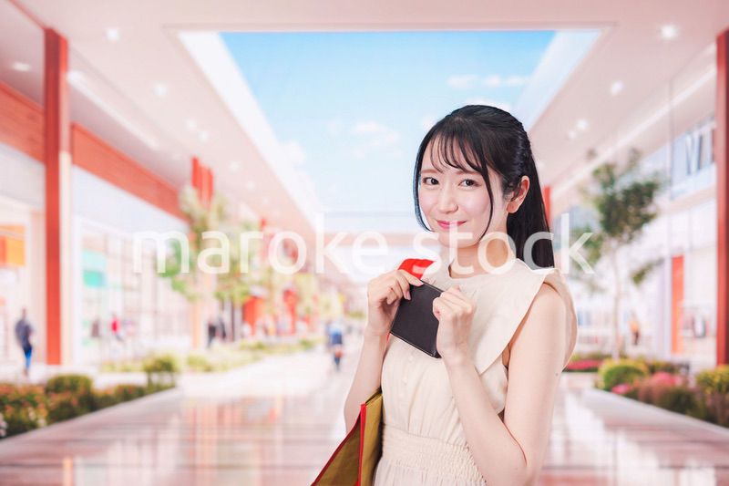 ショッピングモールで笑顔で買い物をする若い女性