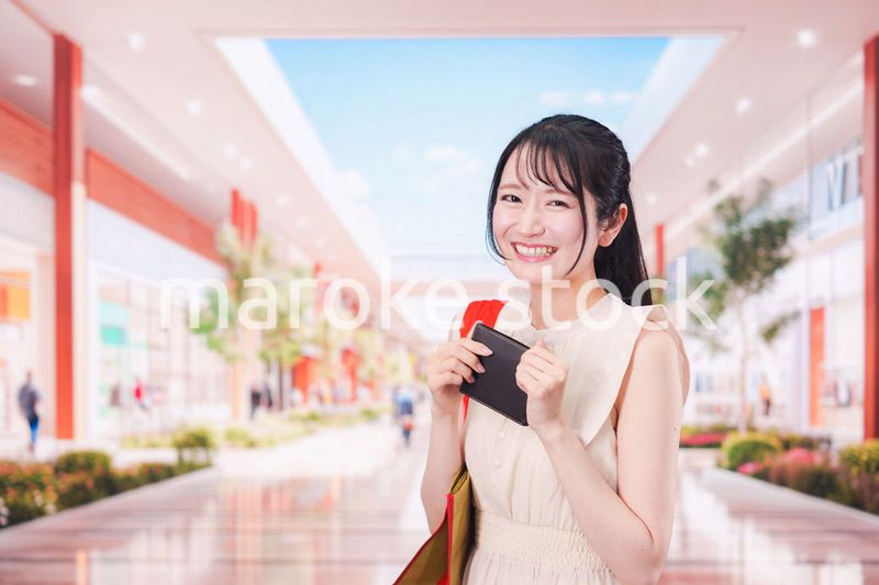 ショッピングモールで笑顔で買い物をする若い女性