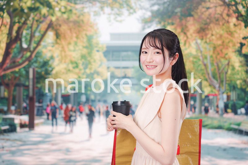 コーヒーを飲みながら外を歩く若い学生