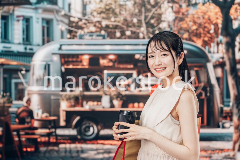 屋外のマーケットプレイスで飲食を楽しむ若い女性