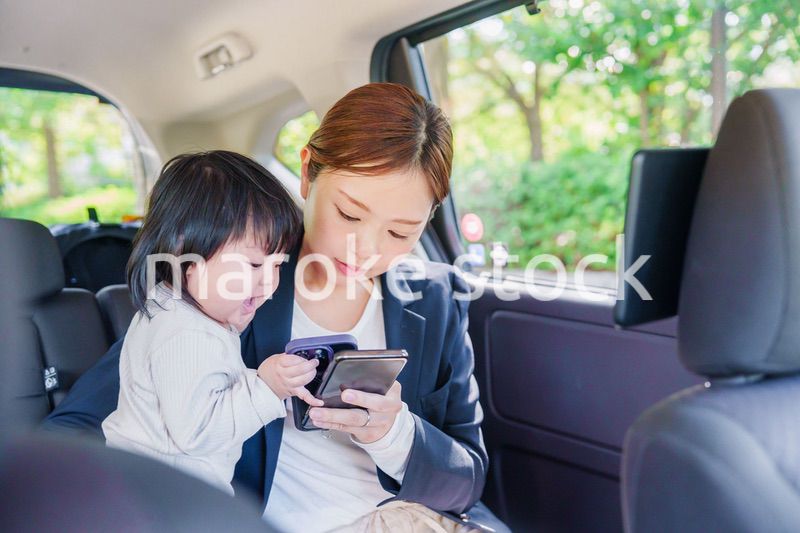 子供と一緒にタクシーに乗る忙しいお母さん