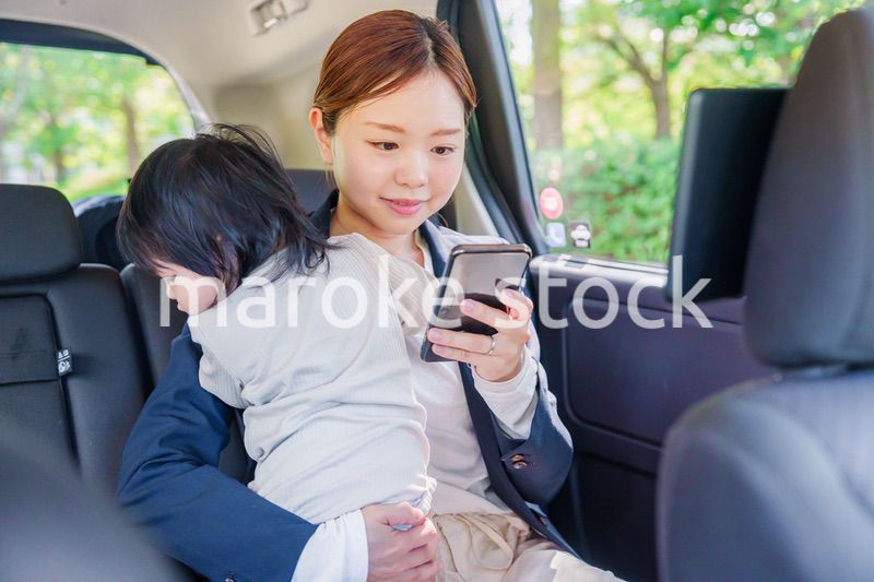 子供と一緒にタクシーに乗る忙しいお母さん
