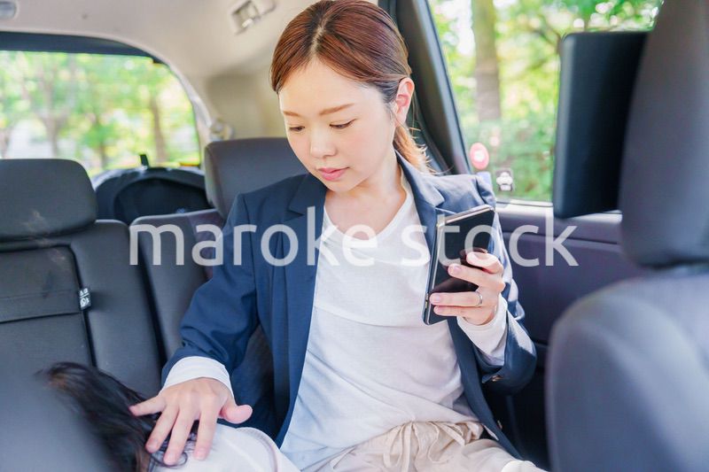 子供と一緒にタクシーに乗る忙しいお母さん