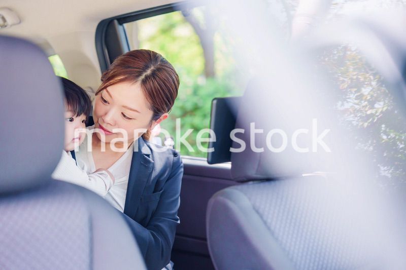 子供と一緒にタクシーに乗る忙しいお母さん