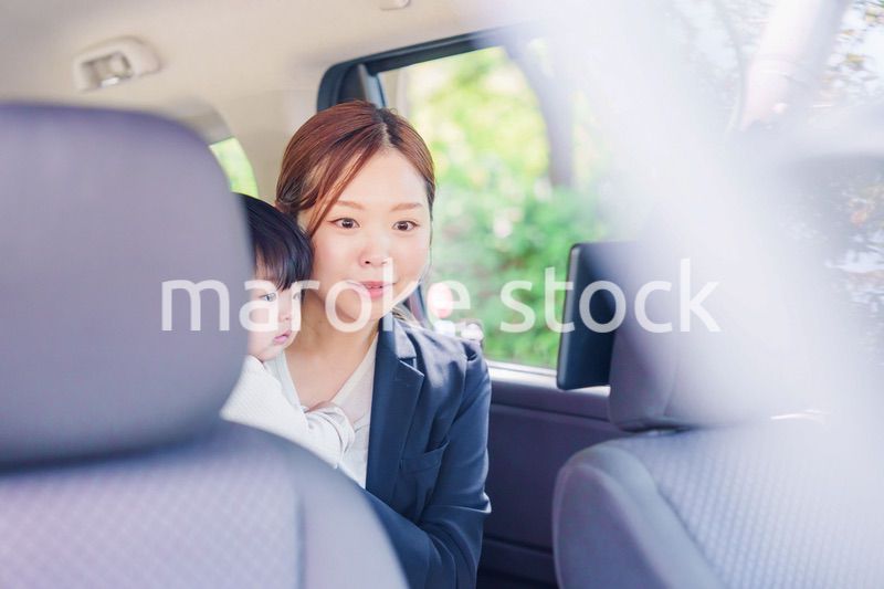 子供と一緒にタクシーに乗る忙しいお母さん