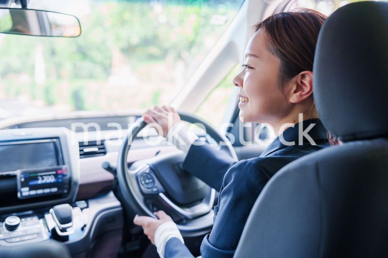 笑顔で運転をするタクシードライバーの女性