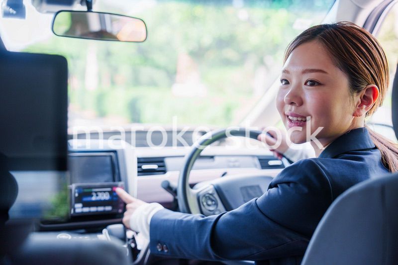 笑顔で料金の案内をするタクシードライバーの女性