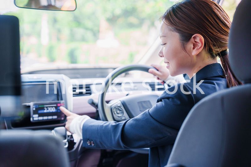 笑顔で料金の案内をするタクシードライバーの女性