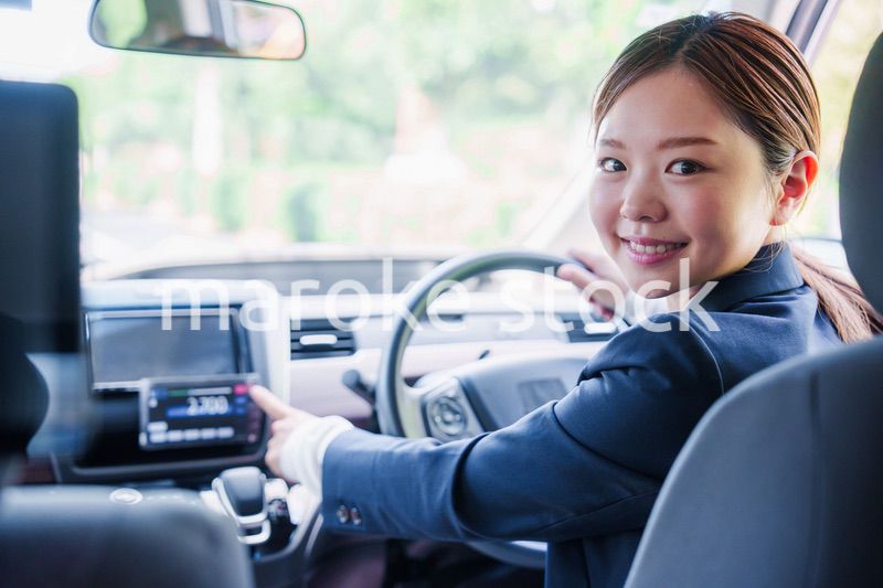 笑顔で料金の案内をするタクシードライバーの女性