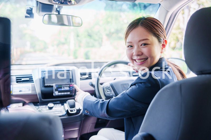 笑顔で料金の案内をするタクシードライバーの女性