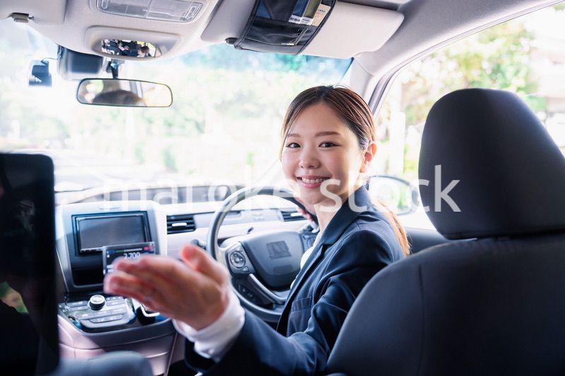 決済の案内をする若い女性のタクシー運転手