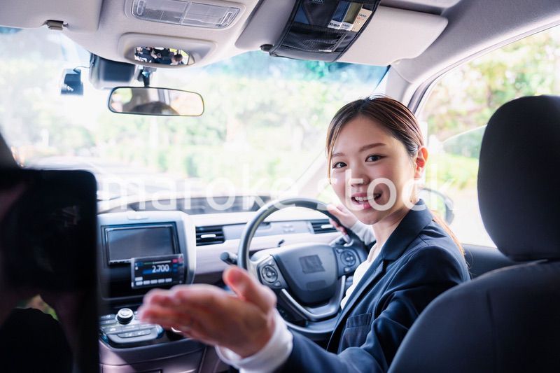 決済の案内をする若い女性のタクシー運転手