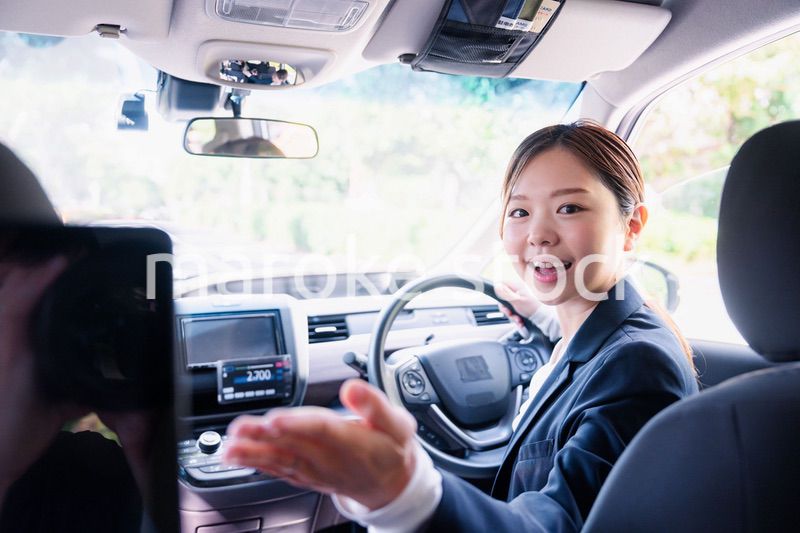 決済の案内をする若い女性のタクシー運転手