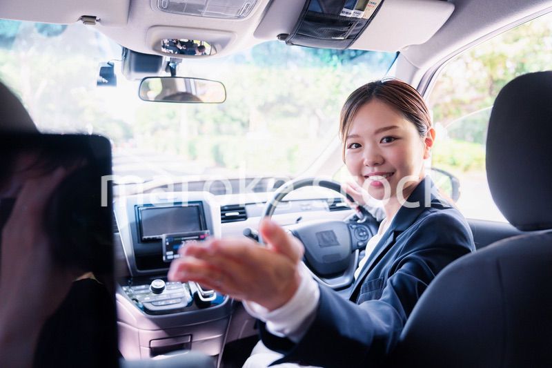 決済の案内をする若い女性のタクシー運転手