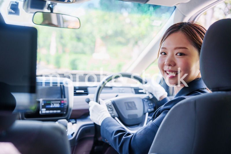笑顔で運転をするタクシードライバーの女性