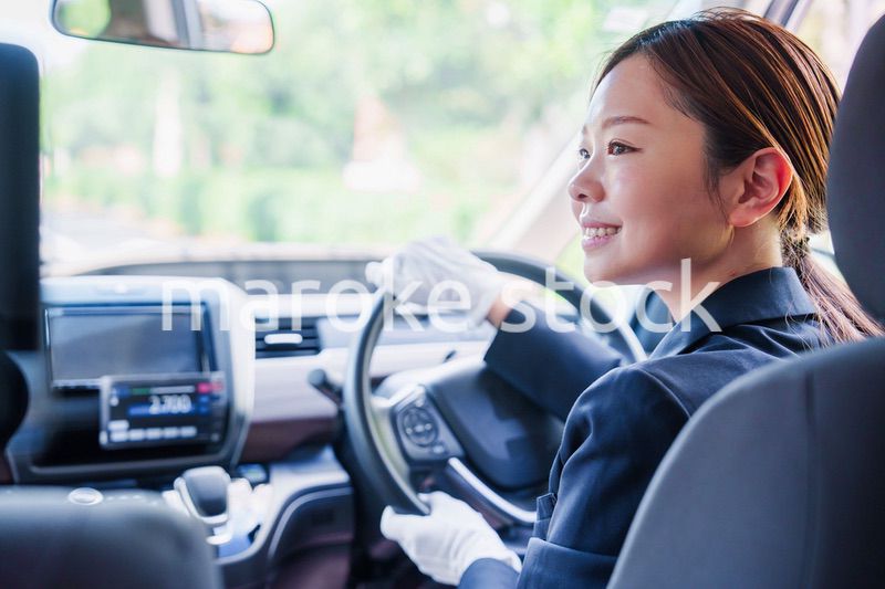 笑顔で運転をするタクシードライバーの女性