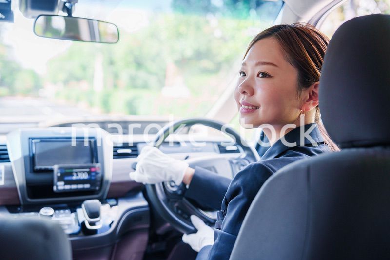 笑顔で運転をするタクシードライバーの女性