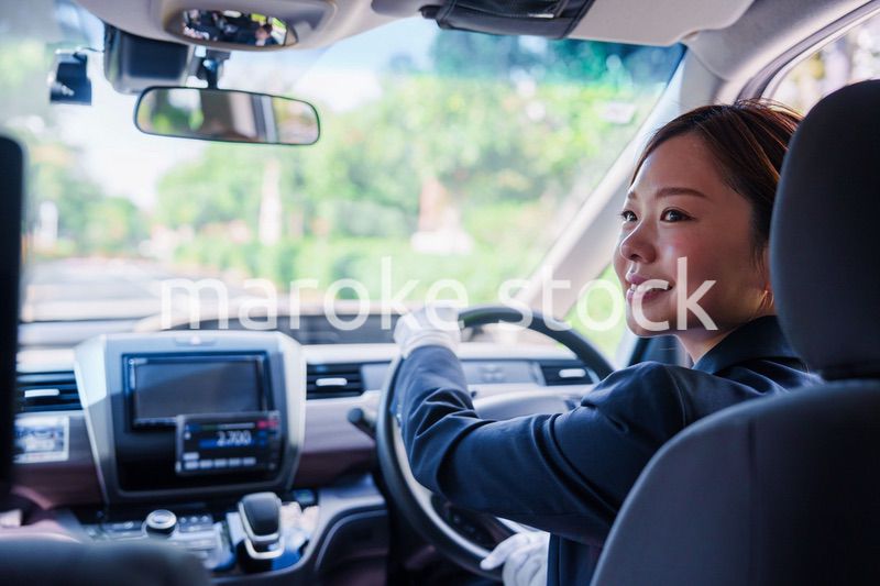 笑顔で運転をするタクシードライバーの女性