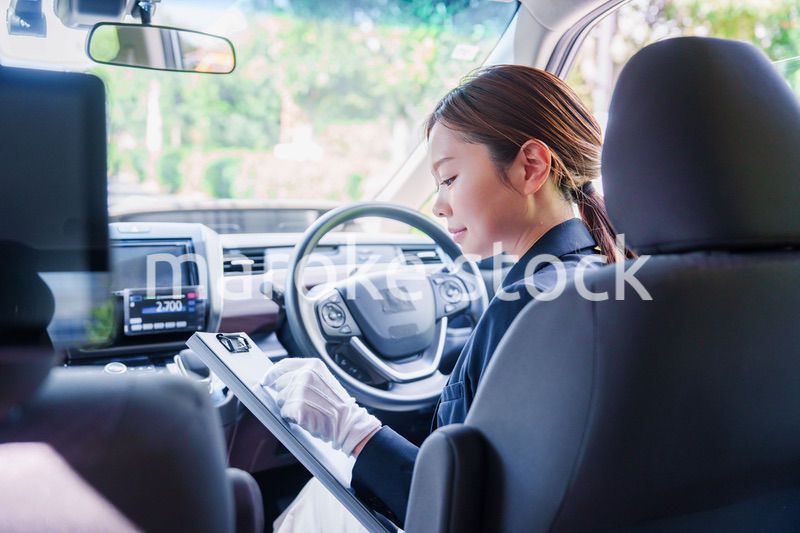 笑顔で運転をするタクシードライバーの女性